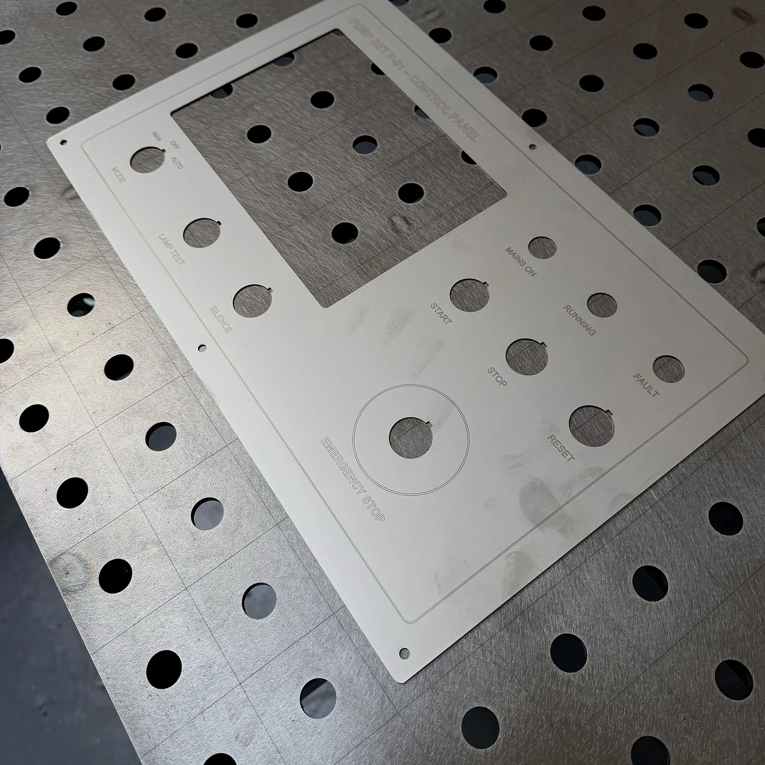 A stainless steel control panel, laser cut and engraved, on our welding table